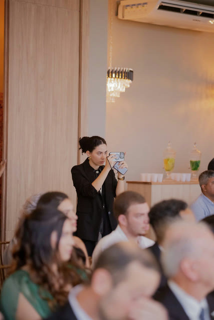 Gabriela gravando um evento com o celular